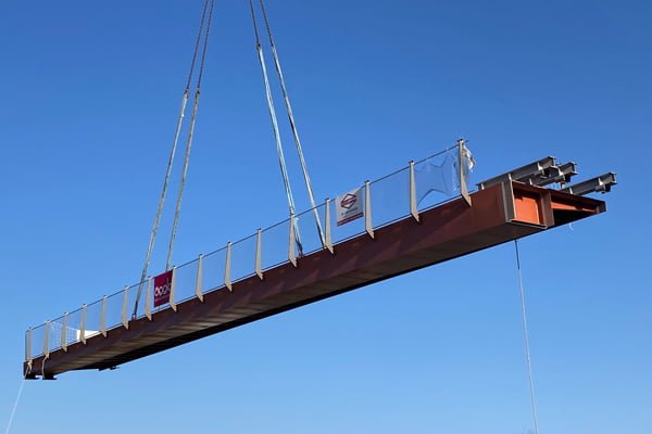 poutre métallique utilisée en ingénierie structurelle, soulevée par des câbles.