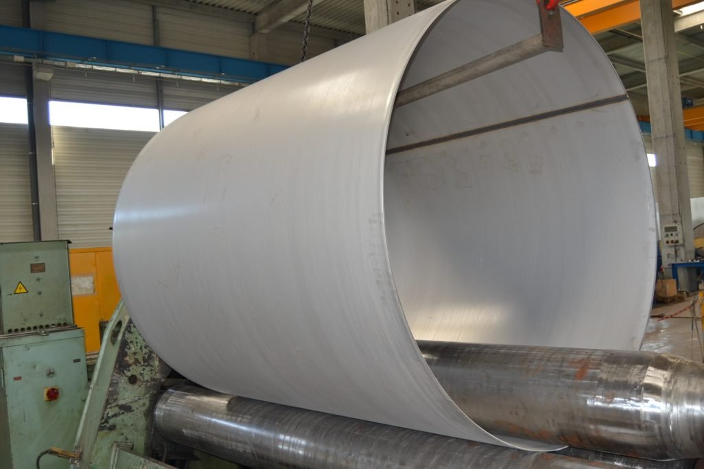 Cylindre métallique en cours de formage dans une usine, illustrant une solution industrielle de haute précision