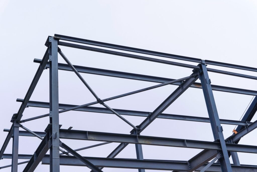 Vue d'une charpente métallique en acier, illustrant la structure robuste et l'assemblage précis des poutres.